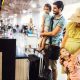 A family happily checks their bags at the airport as they travel with children.